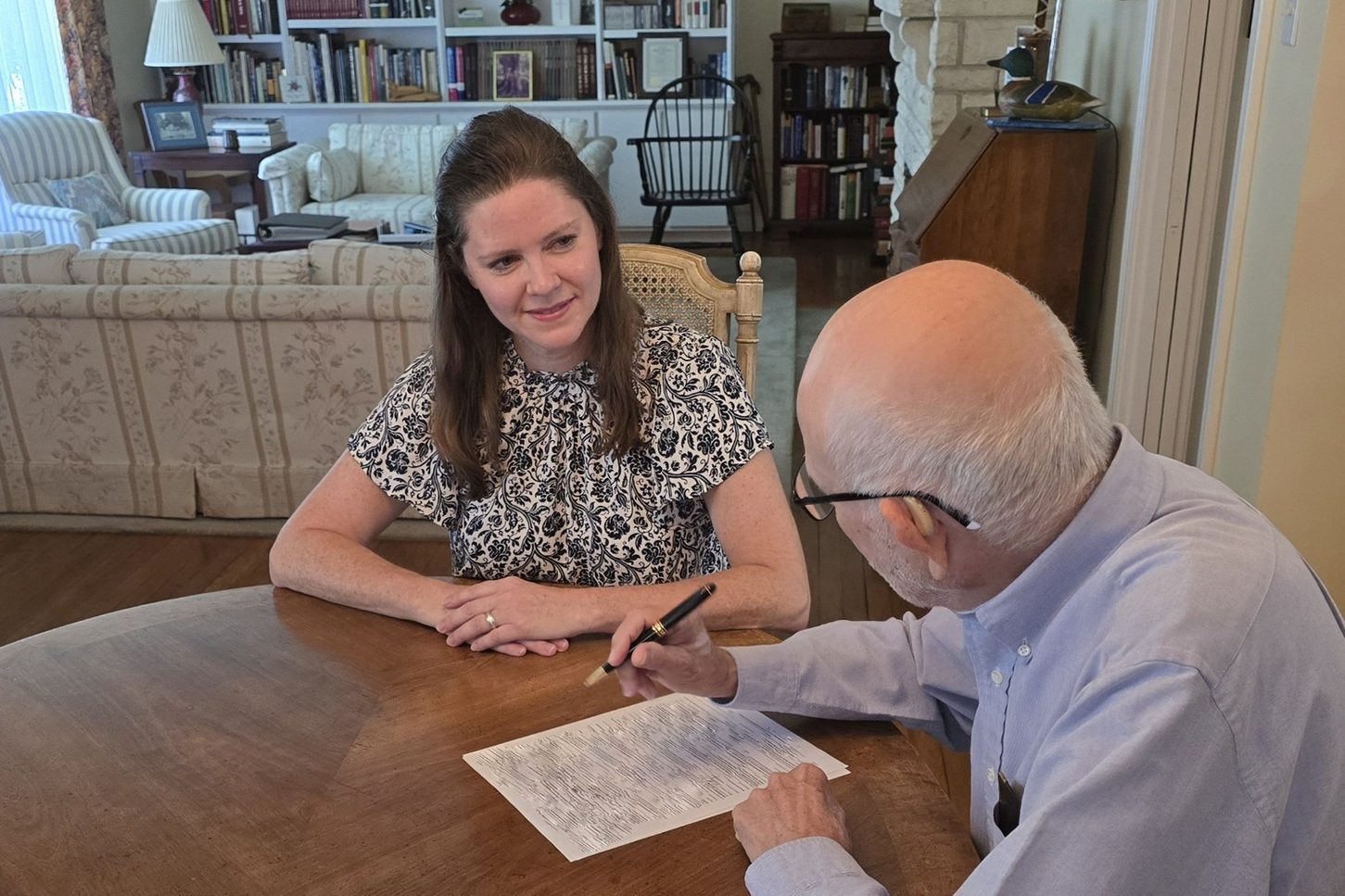 Attorney Christina Clayton reviewing an estate planning document with a client as he signs it